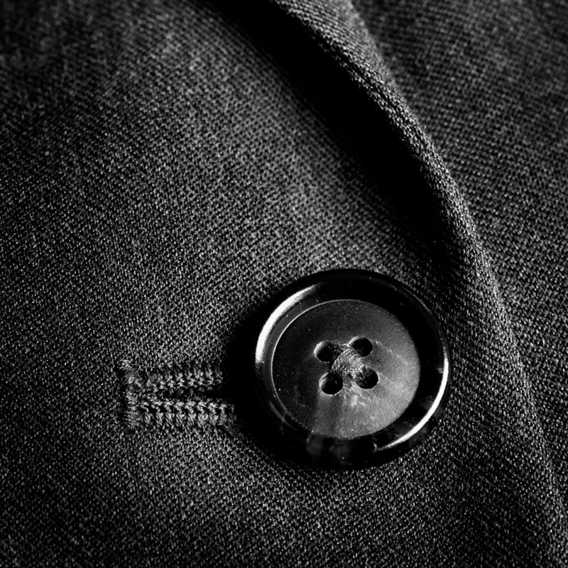 Black button on dark fabric.