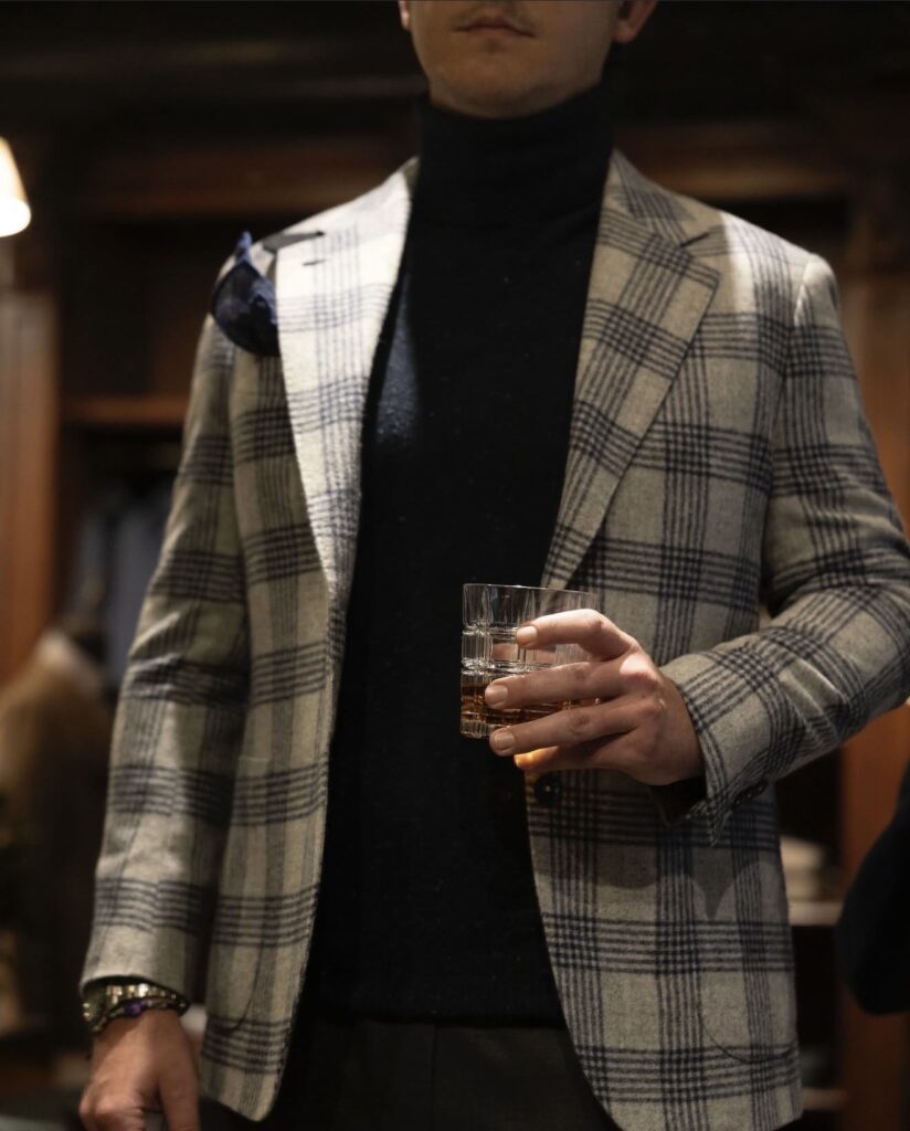 A man layering a fine gauge sweater under a tailored jacket