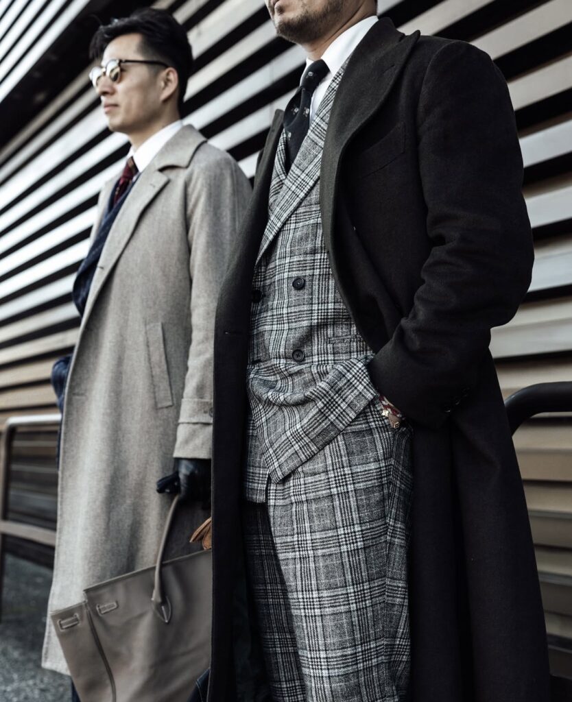 Two well-dressed men in winter wearing an overcoat and layered tailoring